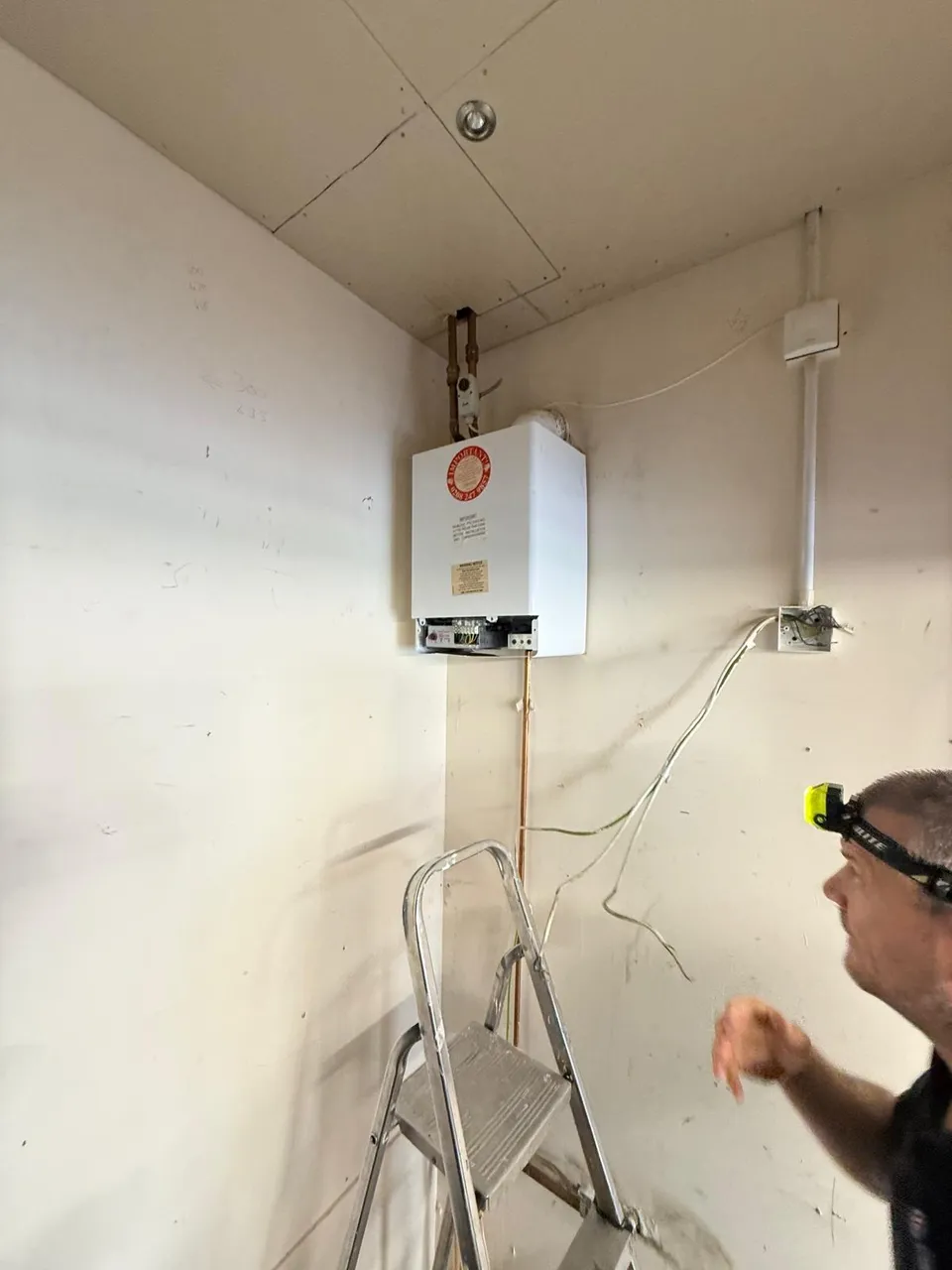 Gas Fire Installation & Servicing in Kirkcaldy and Fife: Engineer assessing an old boiler before a new boiler installation