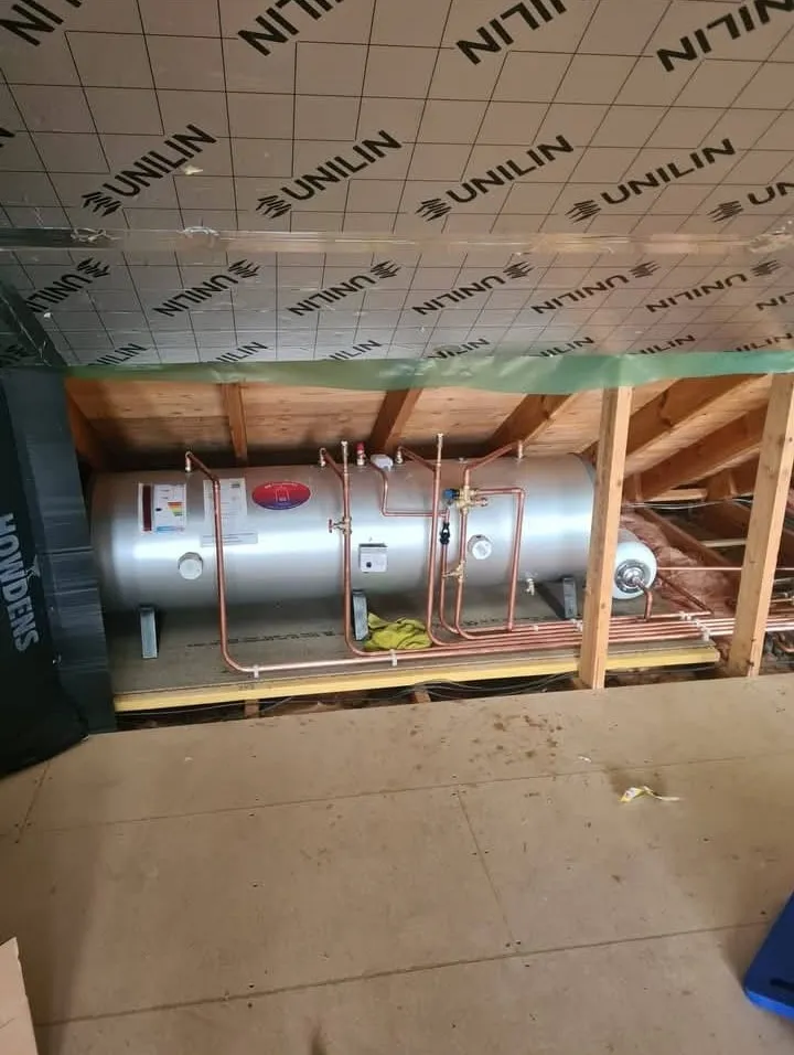 Horizontal unvented hot water cylinder installed in a loft with copper pipework