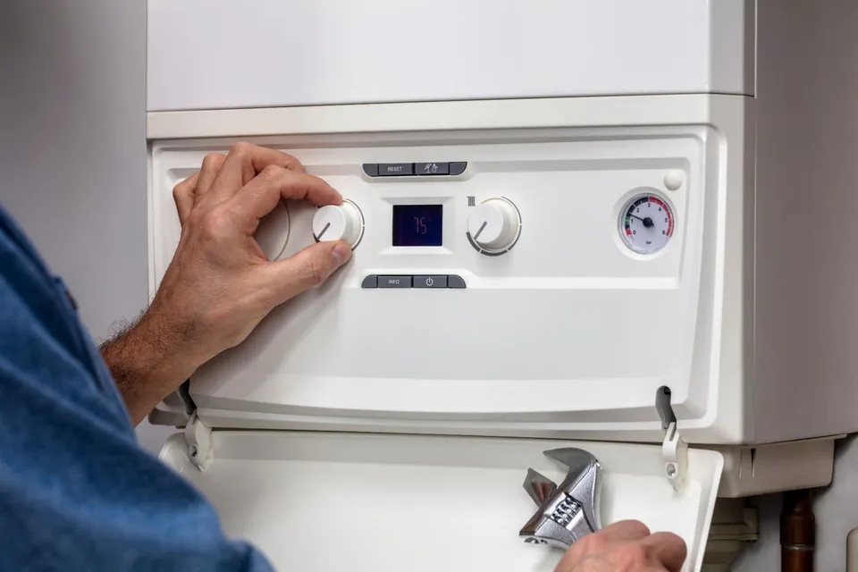 Boiler Servicing in Kirkcaldy and Fife: Engineer adjusting boiler temperature controls during a boiler service